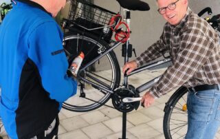 Zwei Männer reparieren ein Fahrrad.